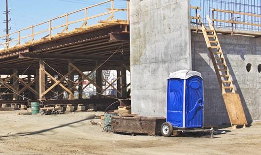 multiple portable toilets arranged at a busy construction site